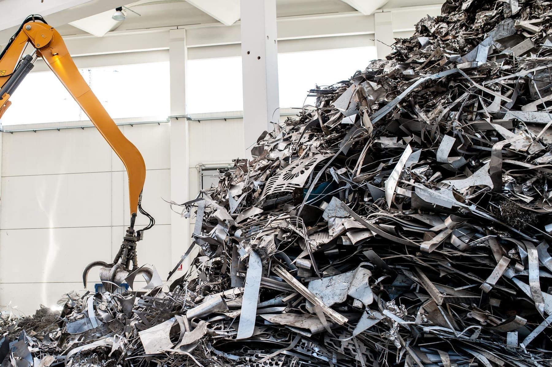 Grab crane handling sorted metal scrap inside a processing hall